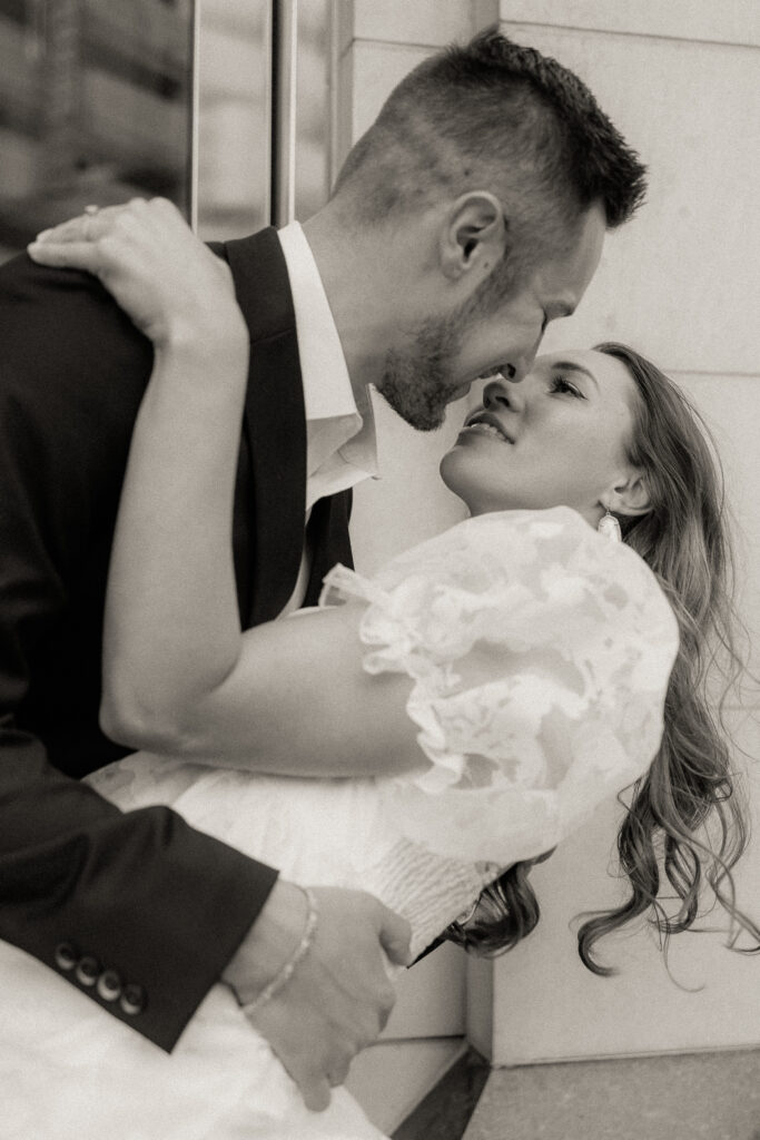 Couple kissing in front of building